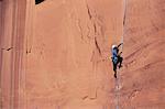 Low angle view of a woman climbing on a rock