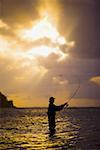 Silhouette of a man fly-fishing