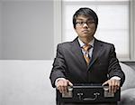 Portrait of a businessman sitting and holding a briefcase