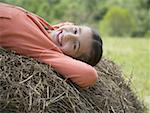 Portrait of a girl lying on a hay bale