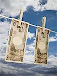 Low angle view of Japanese paper currency pegged on a clothesline