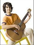 Portrait of a teenage boy playing the guitar