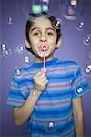 Portrait of a boy blowing bubbles with a bubble wand