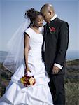 Newlywed couple standing together with their eyes closed