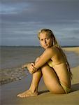 Porträt von ein junges Mädchen am Strand sitzen