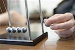 Close-up of a person's hand holding a pendulum