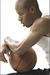 Portrait d'un jeune homme assis et tenant un ballon de basket