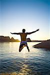 Rückansicht eines jungen Mannes, der in einen See springen