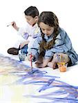 Girl and her brother painting on the floor