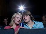 Boy and girl sharing beverage at movie theater