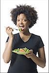 Portrait d'une jeune femme manger salade