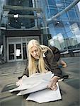 Businesswoman picking paperwork up off the ground