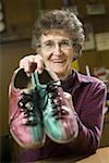 Portrait d'une femme senior, une paire de chaussures de bowling