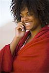 Nahaufnahme einer jungen Frau, eingewickelt in ein Handtuch, das Gespräch auf ein Mobiltelefon