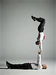Profil von zwei männlichen Akrobaten in Anzügen durchführen