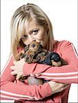 Portrait of a young woman holding four puppies