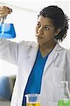 Close-up of a young woman holding a conical flask with liquid