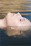 Profile of a young woman floating in water