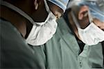 Profile of two surgeons operating in an operating room