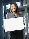 Portrait of a businesswoman holding a blank sign