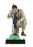 Businessman playing golf on artificial turf