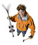 High angle view of a young man holding skis and a ski pole