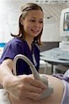 Female nurse performing an ultrasound on a pregnant woman