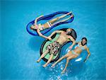 High angle view of a young couple with a mid adult woman in a swimming pool