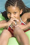 Portrait of a girl sitting on float in a pool