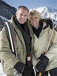 Portrait d'un couple adult tenue d'équipement de ski