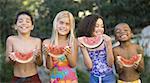 Close-up of children holding watermelons and smiling