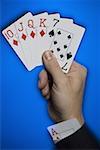 Close-up of a person's hand holding cards
