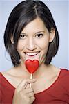 Portrait of a young woman licking a lollipop