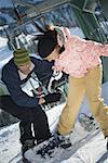 Mid adult man and a young woman skiing