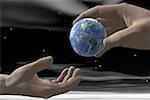 Close-up of a person's hand passing a globe to another person's hand