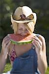 Junge Frau beißt ein Stück einer Wassermelone