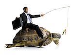 Businessman riding sea turtle with carrot on stick