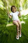 Portrait of a girl swinging on a swing