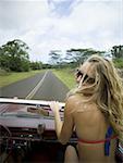 Rear view of a young woman sitting in a car