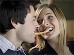 Close-up of a young couple sharing a french fry