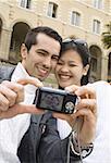 Low angle view of a young couple taking a photograph of themselves