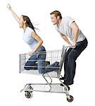 Man pushing shopping cart with girlfriend inside