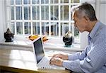 Profile of a mature man using a laptop computer