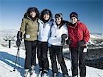Four women standing outdoors in winter with skis