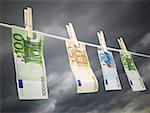 Close-up of Euro banknotes pegged to a clothesline