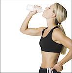 Profile of a young woman drinking water from a bottle