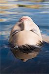 Close-up of a young woman floating on the surface of a lake