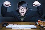 Man with headset making fists and sitting at keyboard