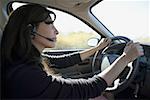 Profil einer Frau ein Auto fahren und eine Headset tragen