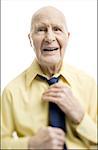 Portrait d'un homme senior ajustant sa cravate